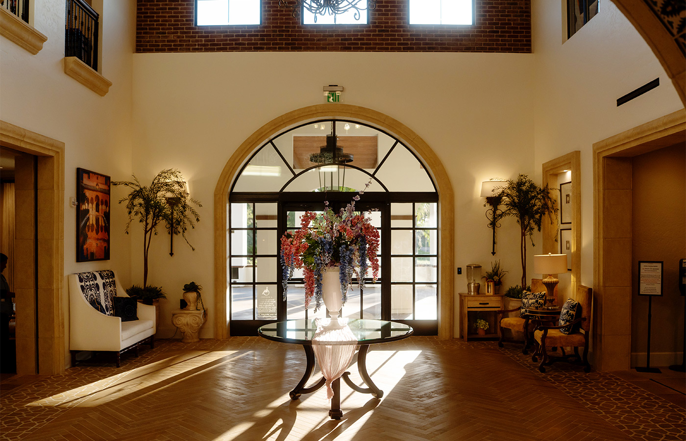 The entrance doors with a table and large floral arrangement.