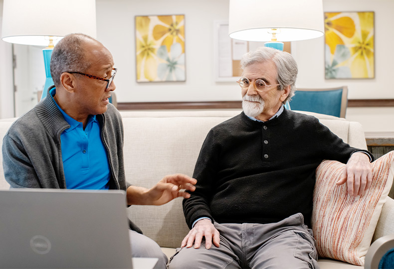 Two people discussing a computer.