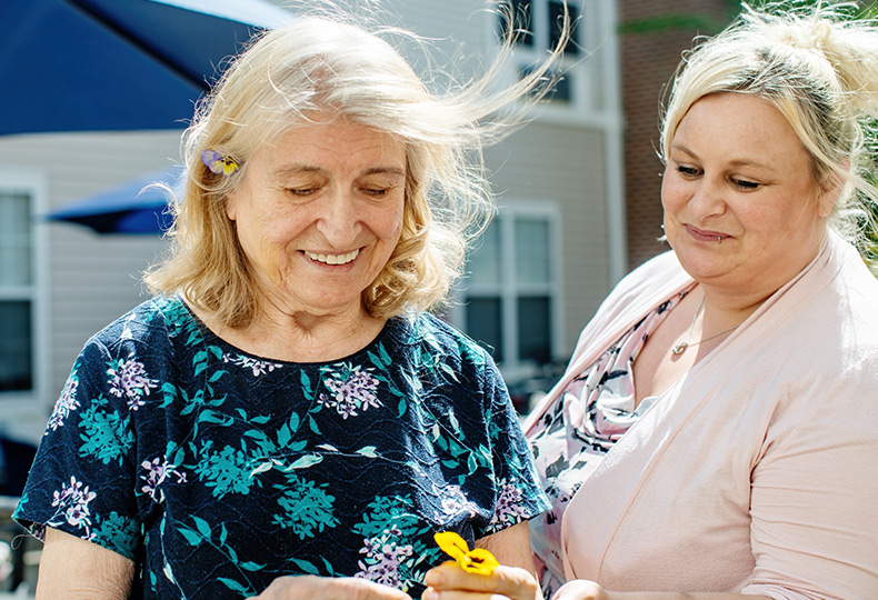 Two people looking at a flower.