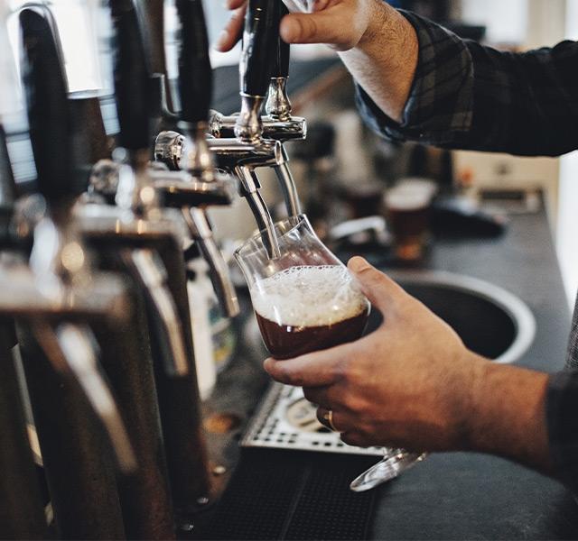 A person pouring a craft beer from a draft.
