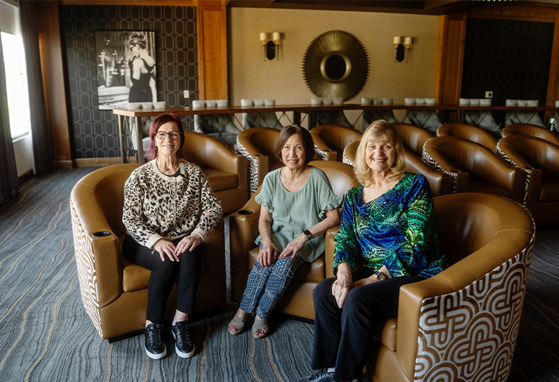 Three people sitting in the theater.