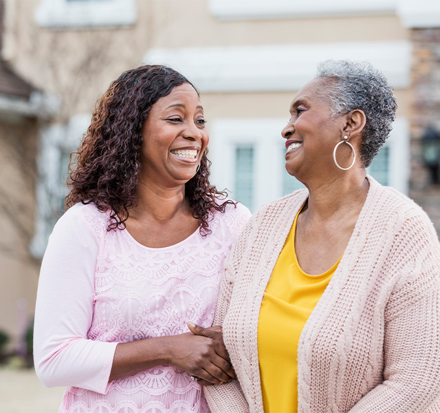 A person with their adult child outside.