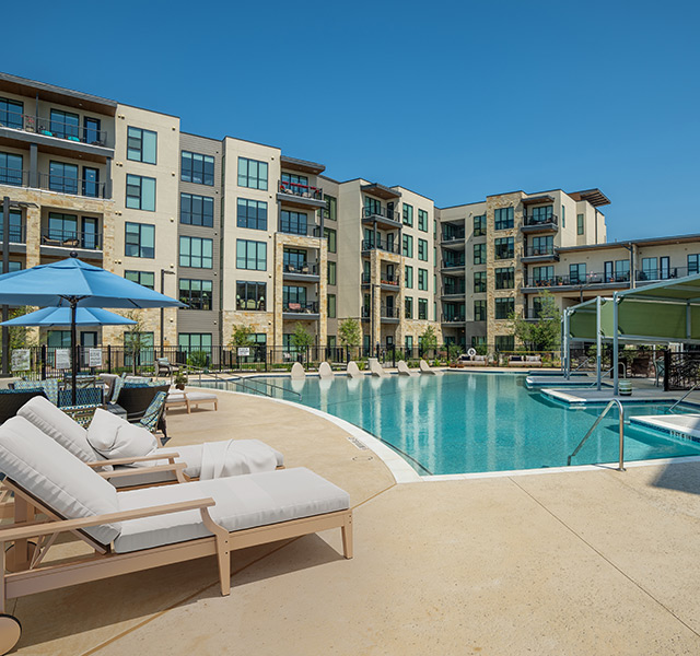 An outdoor pool with cabanas and lounge chairs.