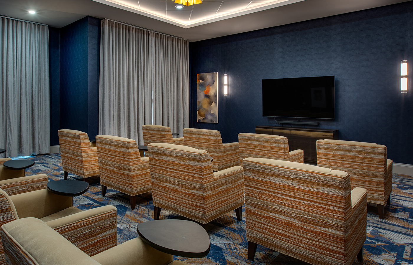 A theater room with big comfy seating and a large screen.