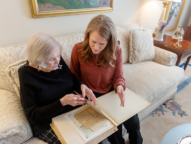 Two people looking at a photo book.