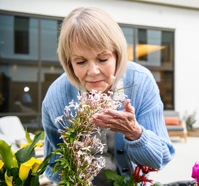 A resident smells flowers.