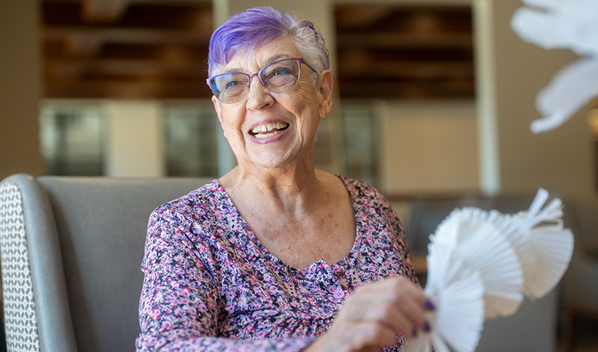 A person with purple hair smiling.