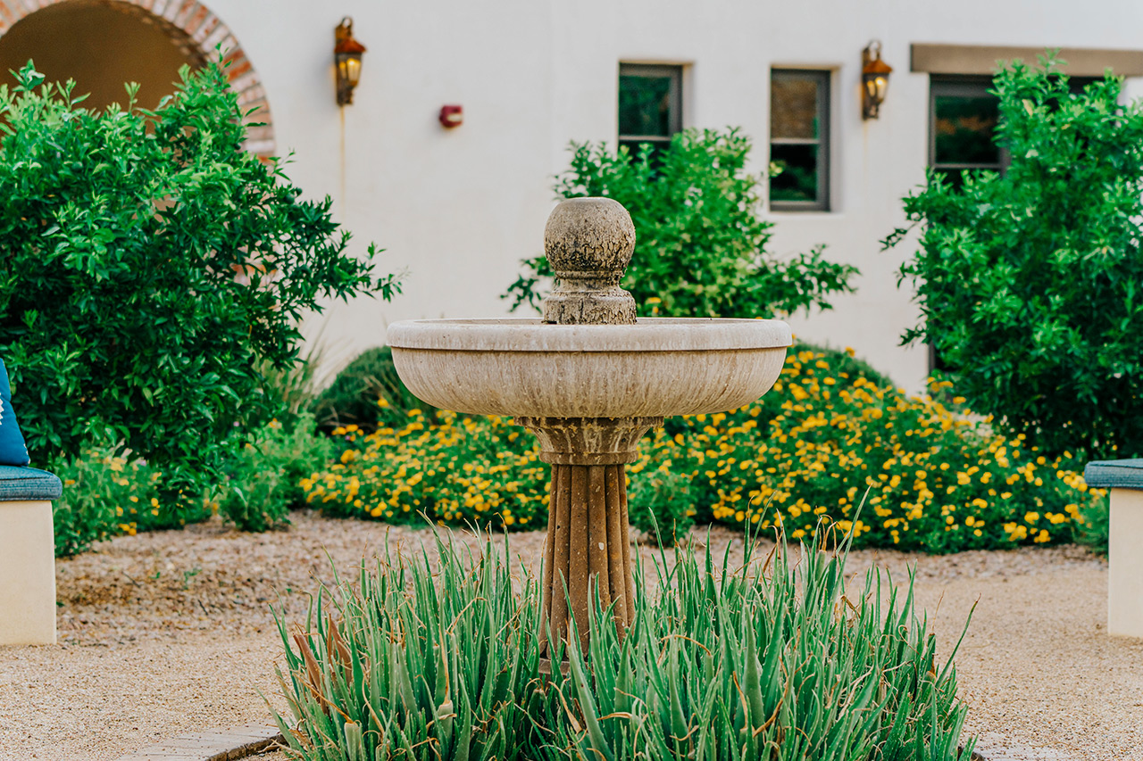 The Hacienda at the River exterior building and courtyard and fountain.