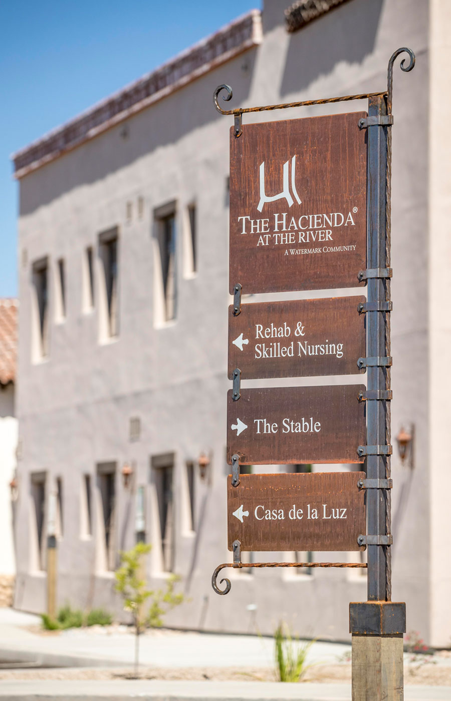 The Hacienda at the River exterior building and courtyard signage.