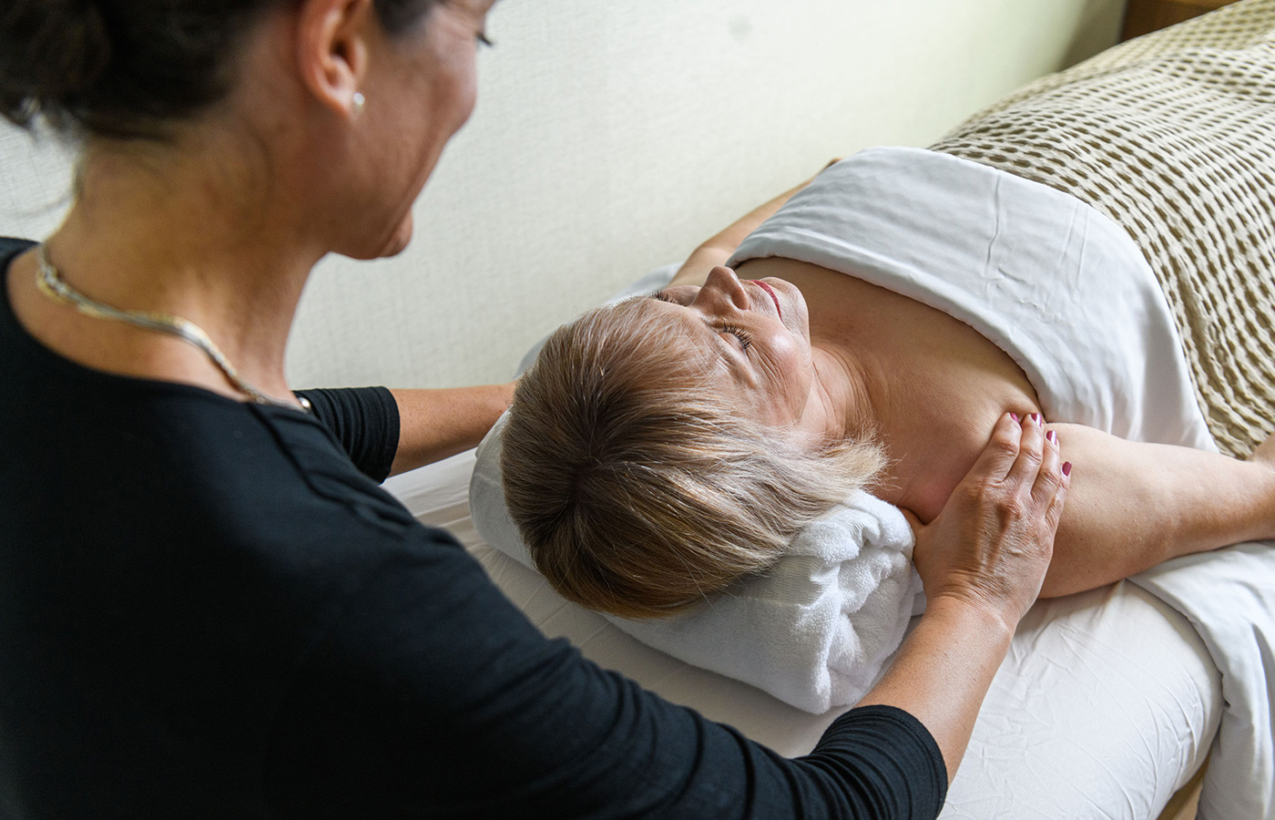 Woman gets massage by masseuse.

