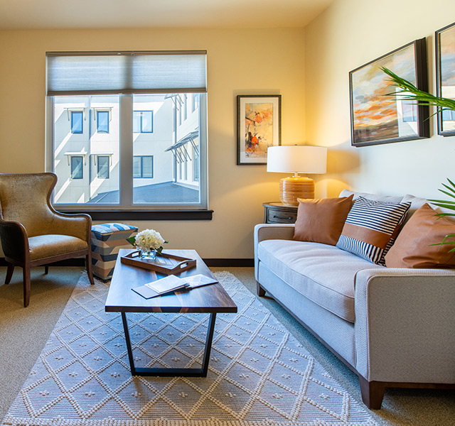 Furnished living room space with sofa, table, and seating area.

