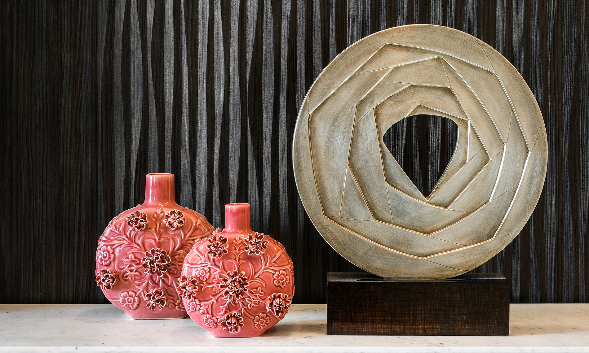 Three pieces of art, including two vases on display.