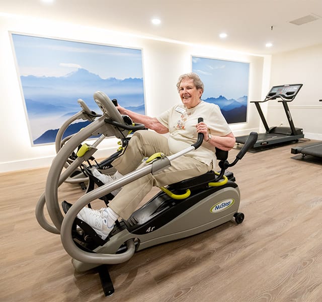 A resident enjoying a workout on a NuStep seated elliptical machine