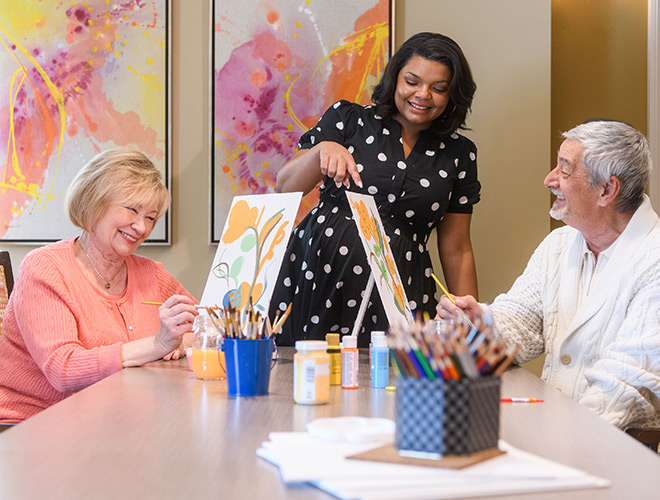 Two residents painting in an art class.