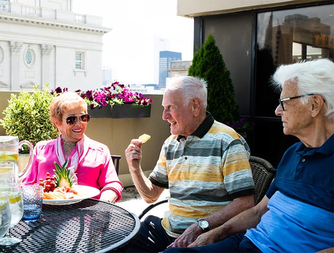 A group of residents enjoying lunch on a patio
