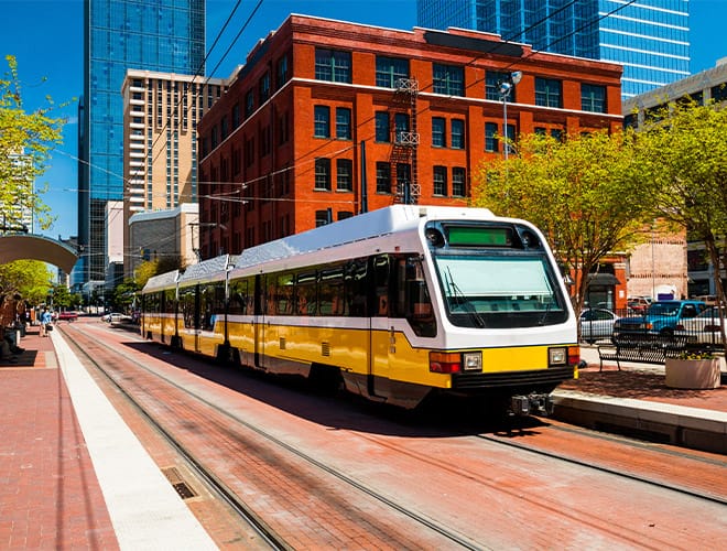Wide angle view of a DART light rail train at a station in downtown Dallas.