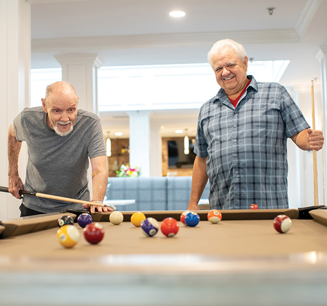 Two residents playing a game of pool.