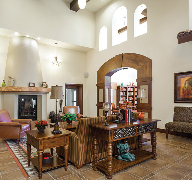 view of lounge area in library with sofa, chairs and fire place