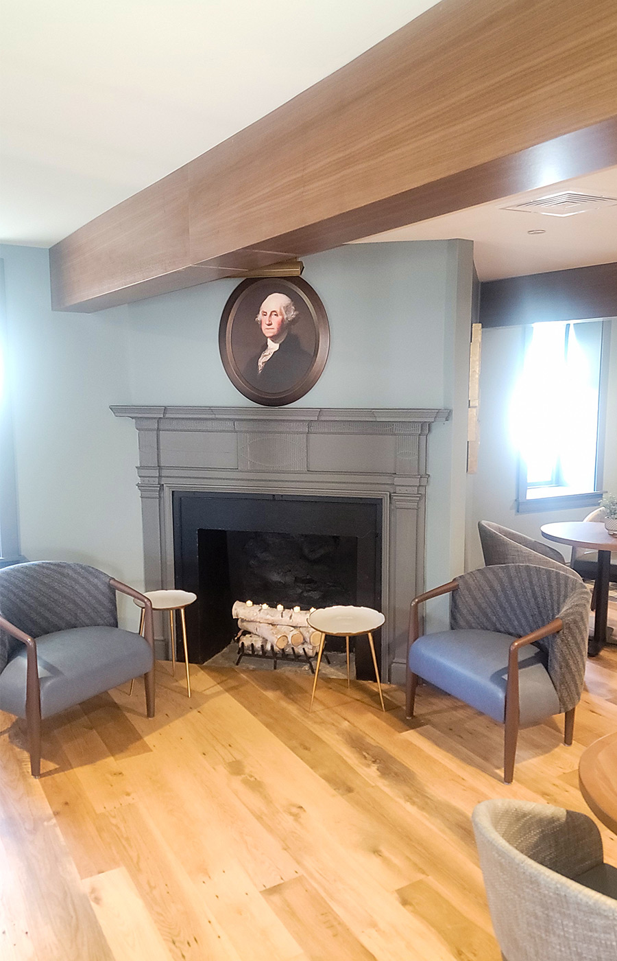 The inside of the Washington House Tavern with a portrait on the wall and fireplace.