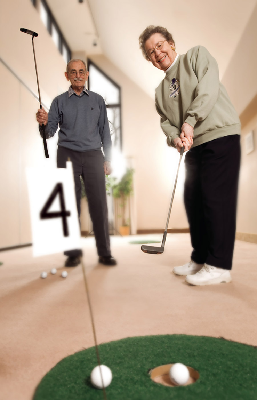 two residents playing indoor put put golf