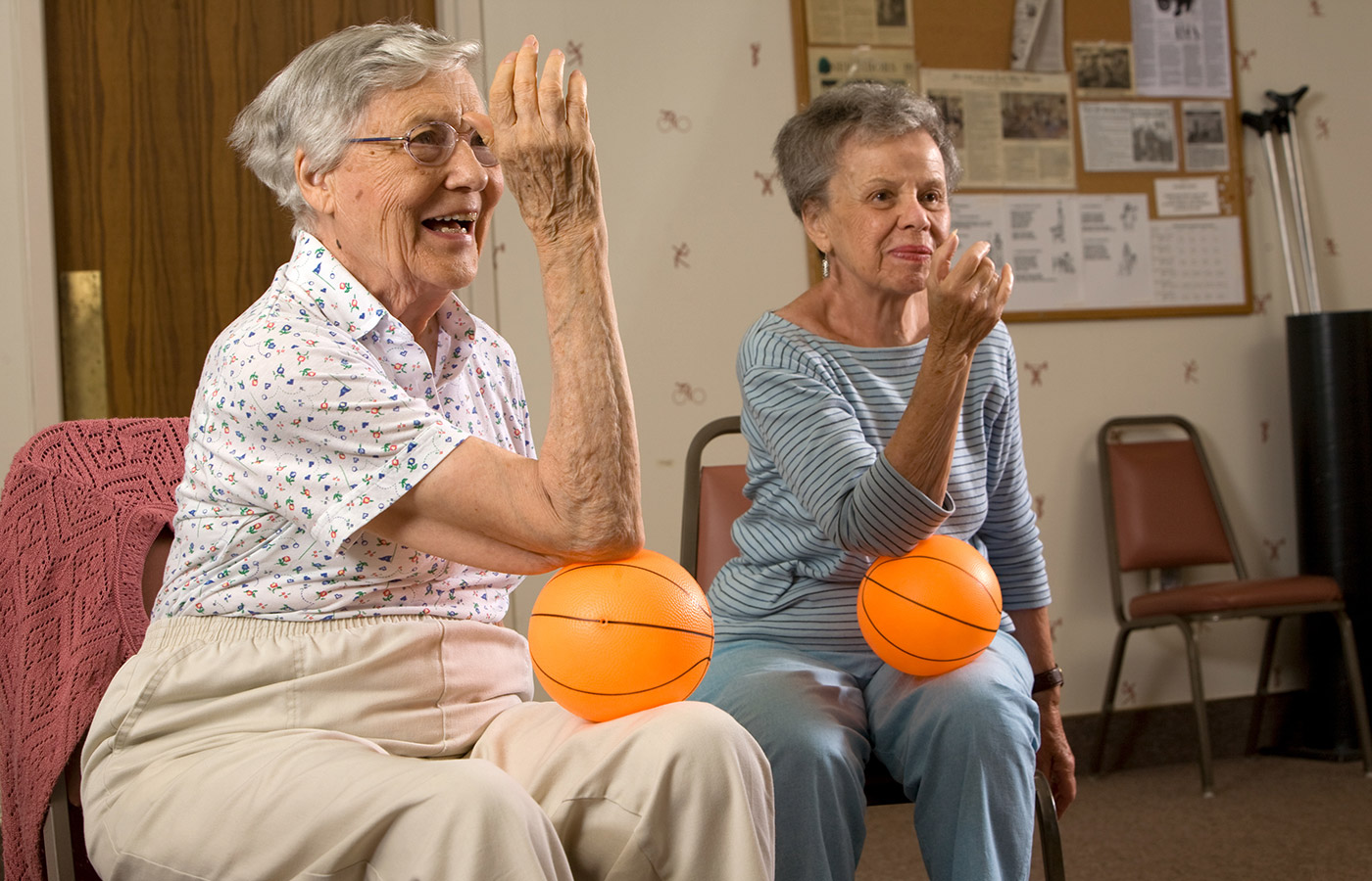 two residents with small balls in fitness class