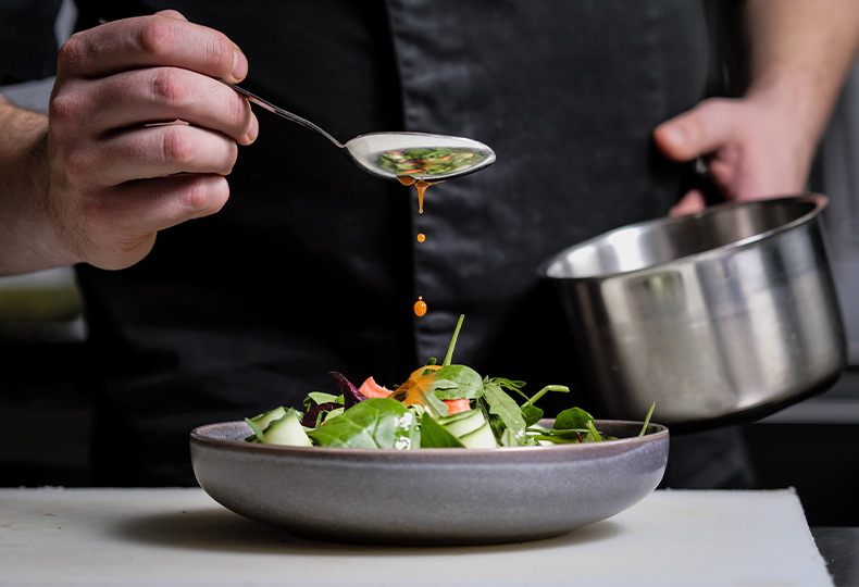 A chef finishing a dish.