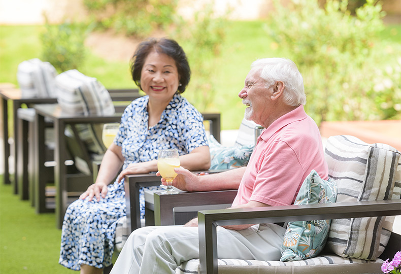 Two people sitting outside with drinks.