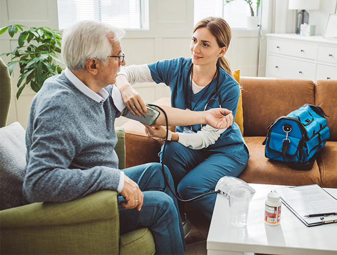 A nurse taking a person's blood pressure at home.