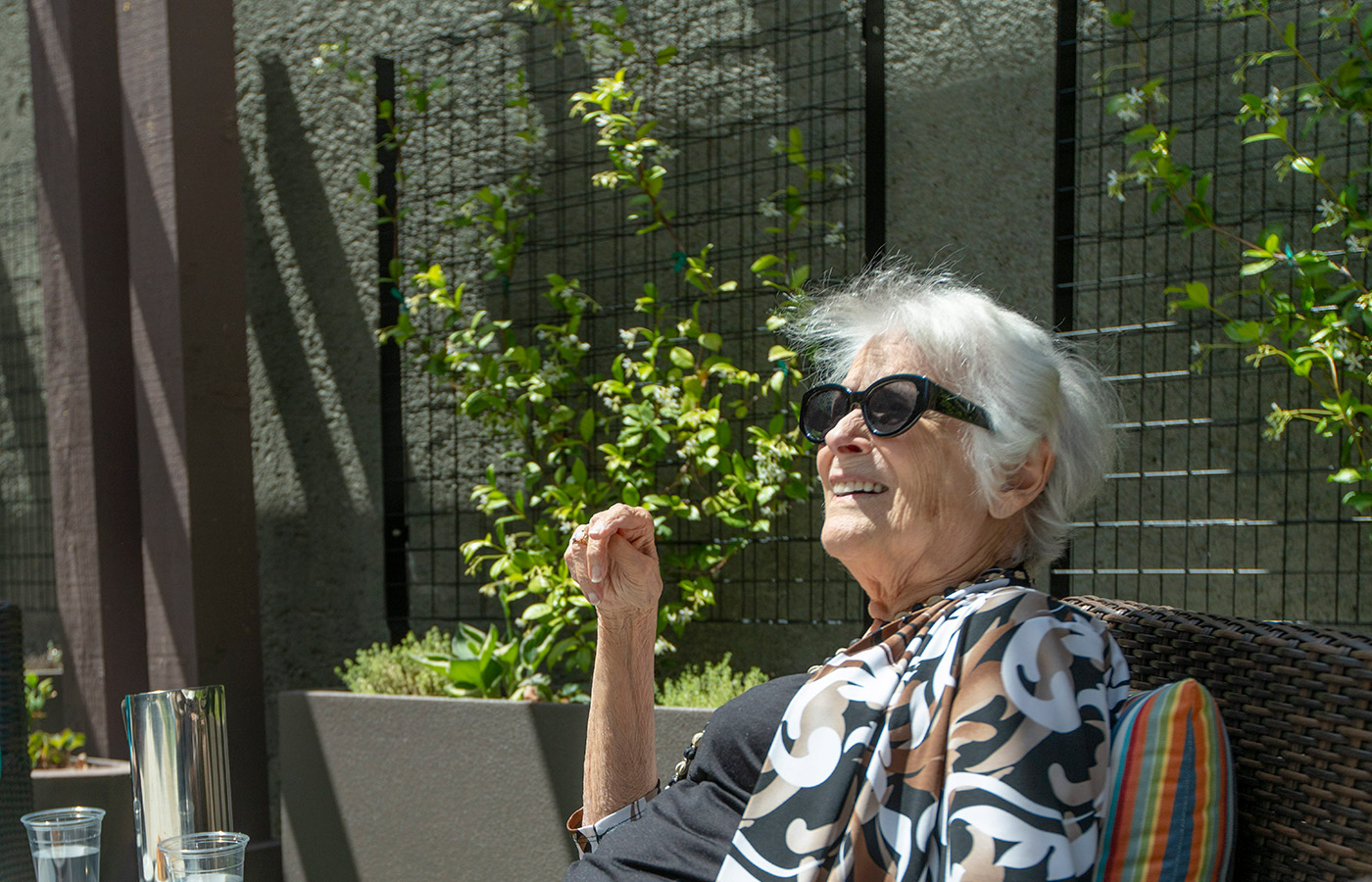A resident is sitting in the courtyard at The Watermark at San Ramon.