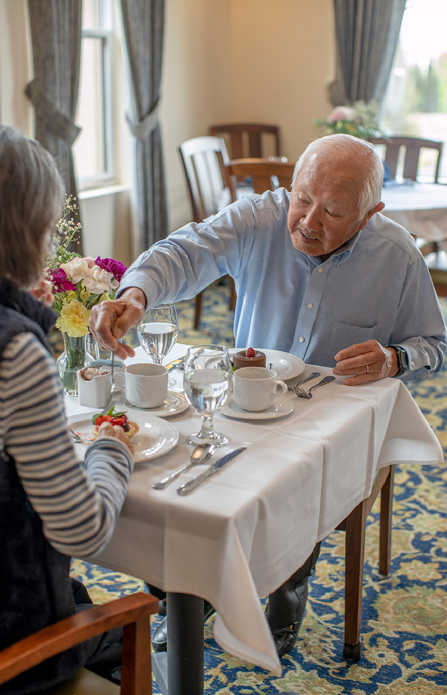 Residents are having a meal together in the dining area at The Watermark at San Ramon.