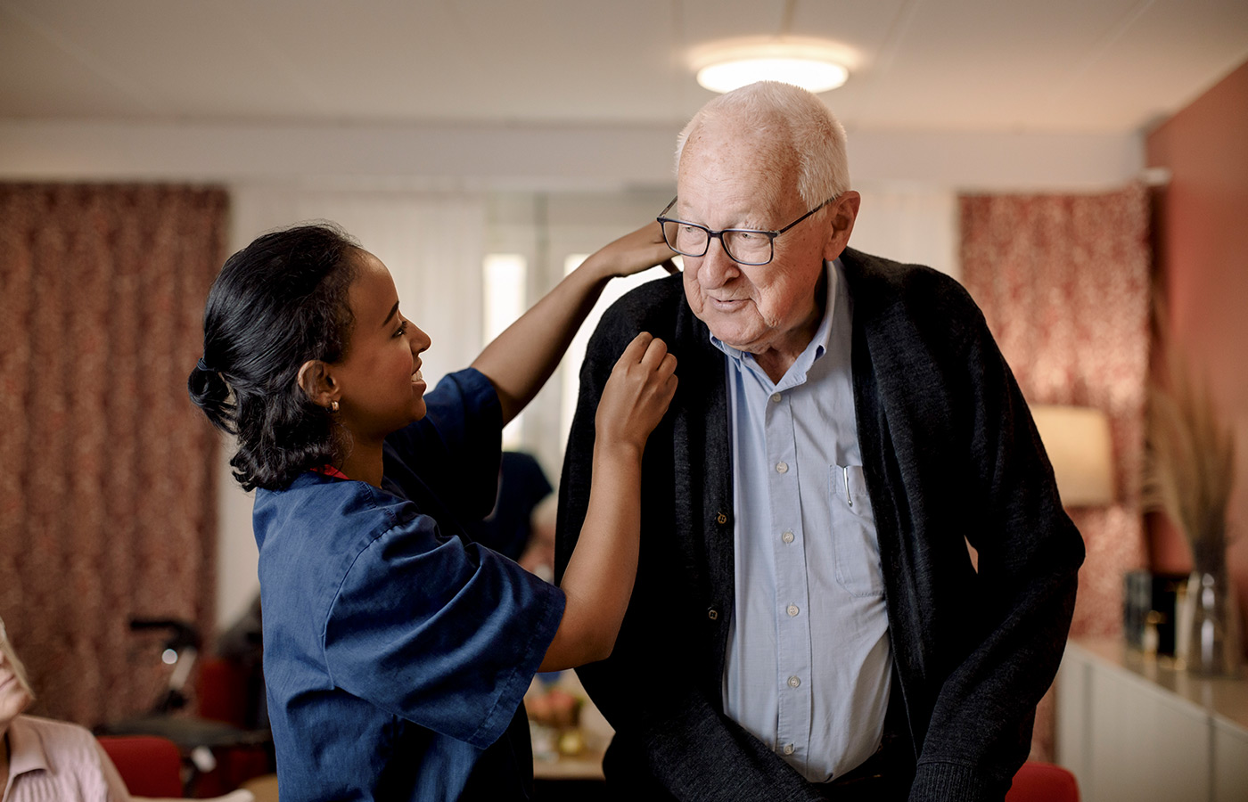 A resident is walking with a caregiver.