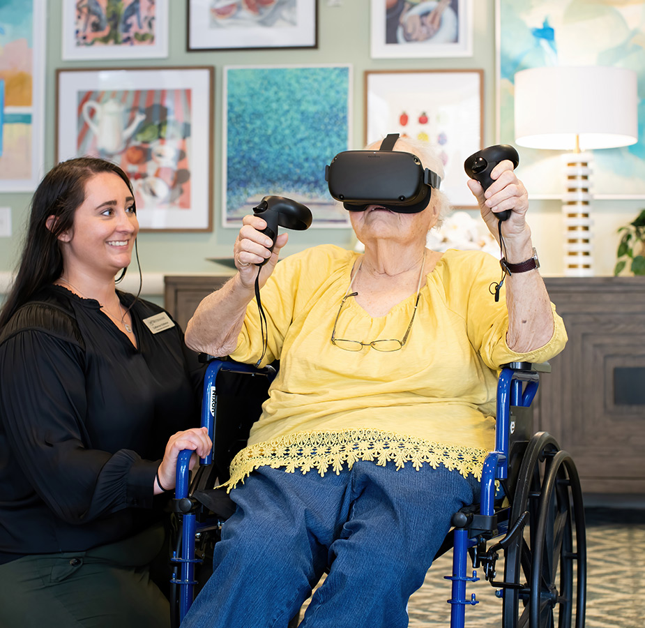 A caregiver helping a resident with a VR headset.