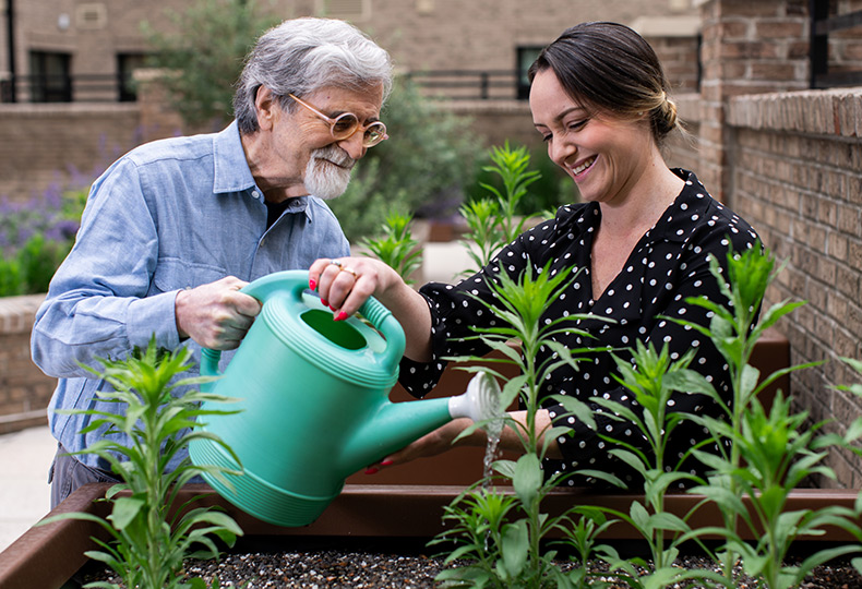 A caregiver helping a resident in the garden.