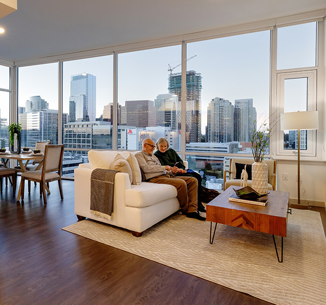 Two people sitting on a couch in their apartment.