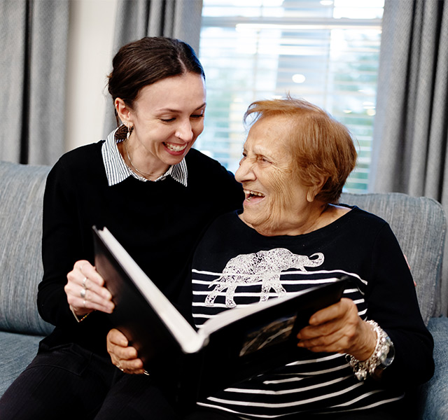 Two people on the couch looking at an album.