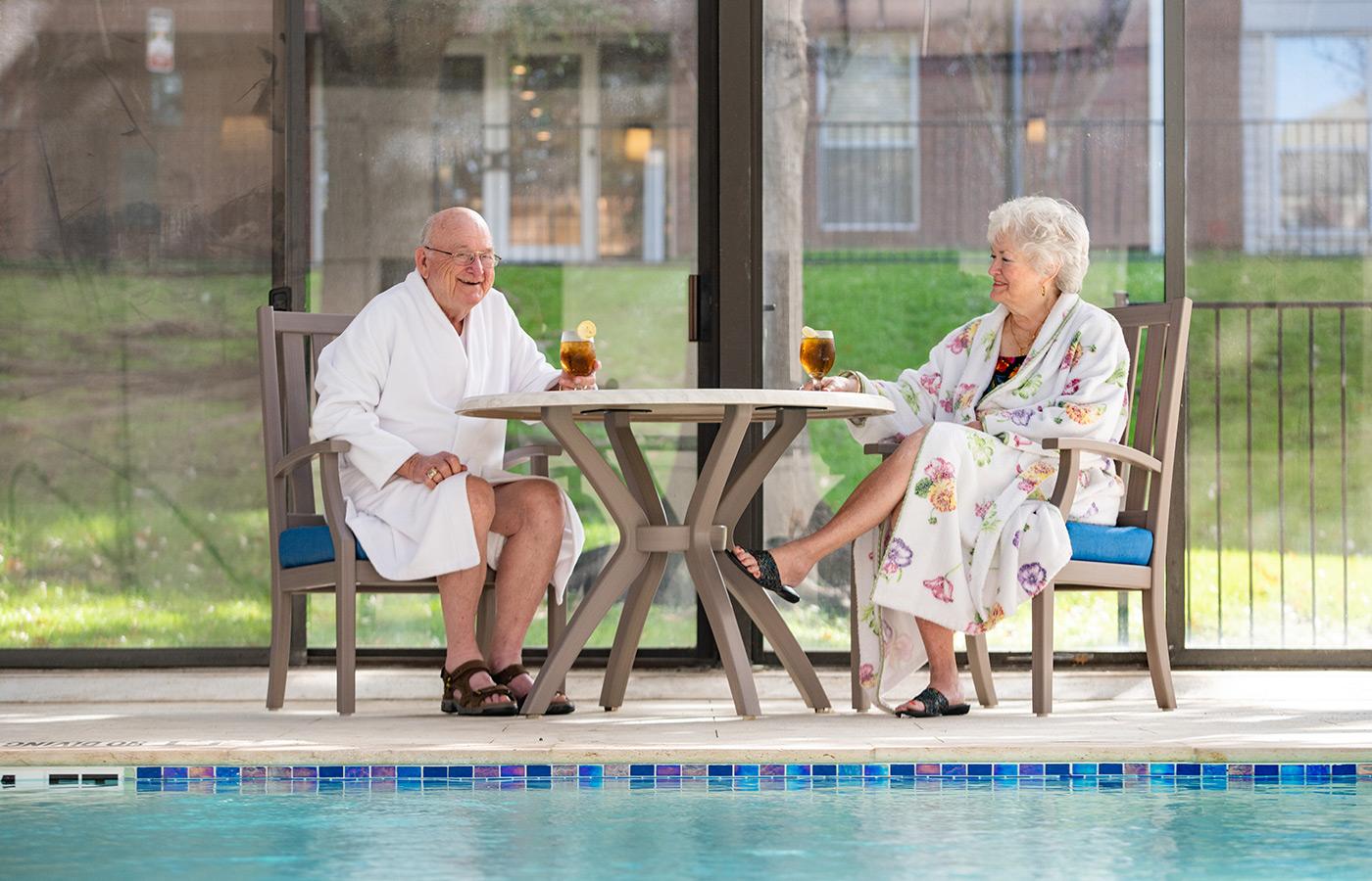 Two people sitting by the pool.