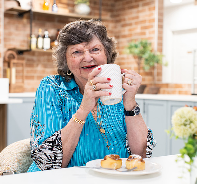 A resident is holding a cup of coffee.