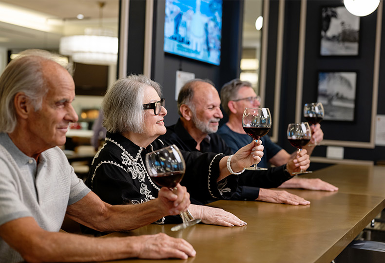 People tasting wine at a bar.