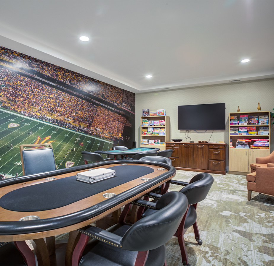 A room with a card table and area for watching tv.