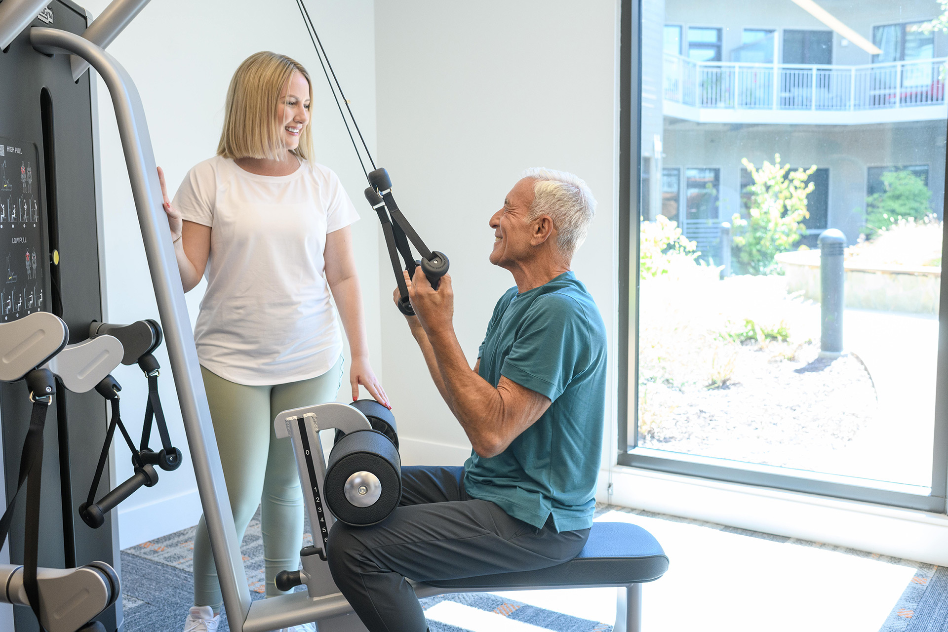 A resident is using a fitness machine in the fitness center.