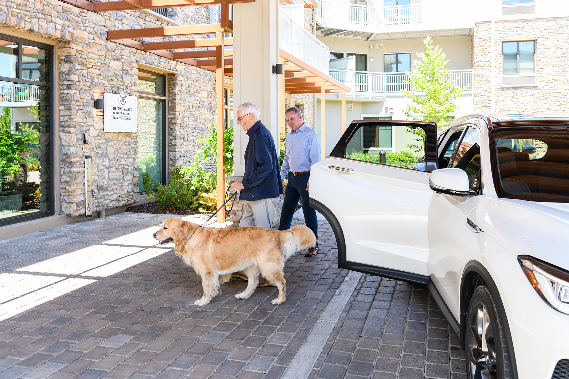 A resident and their dog are in the valet area at The Watermark at Napa Valley.