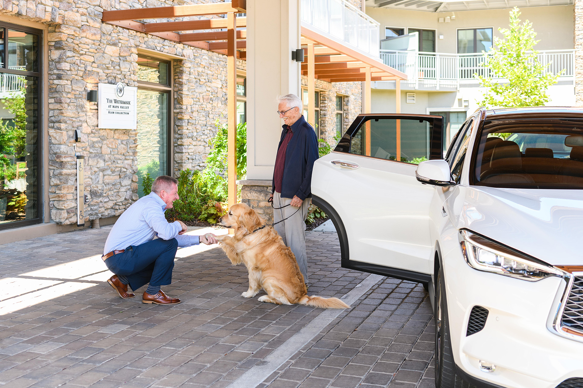A resident and their dog are in the valet area at The Watermark at Napa Valley.