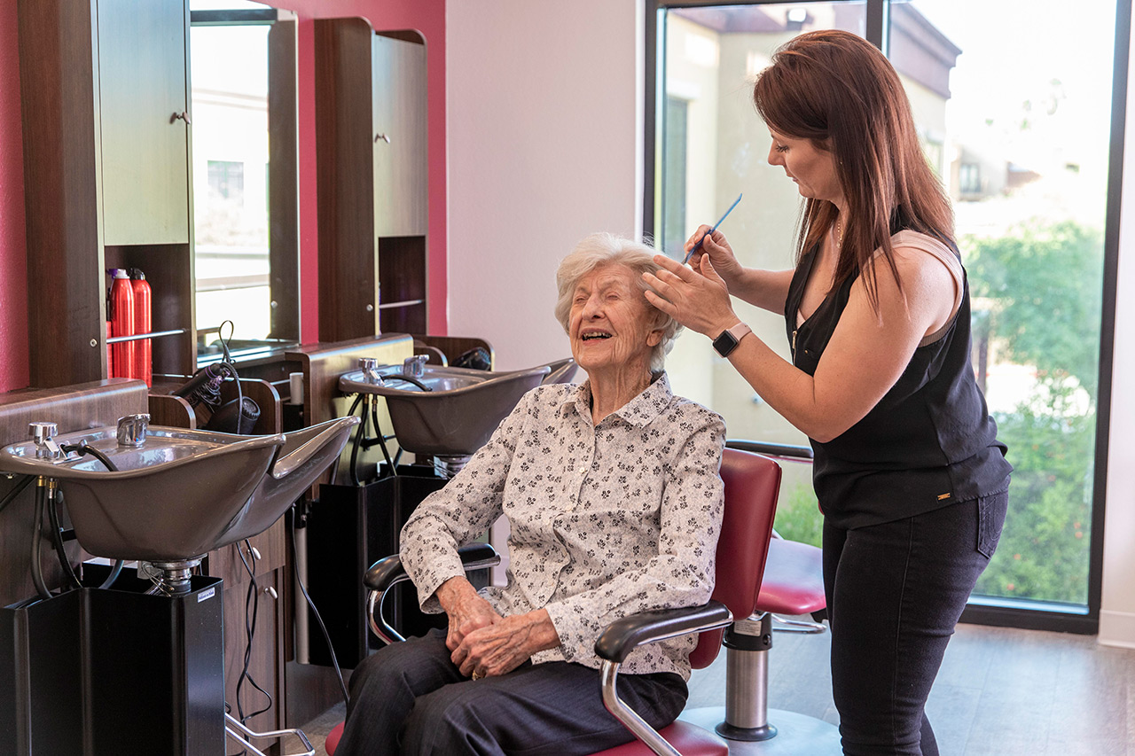 A resident is having their haircut at the salon.