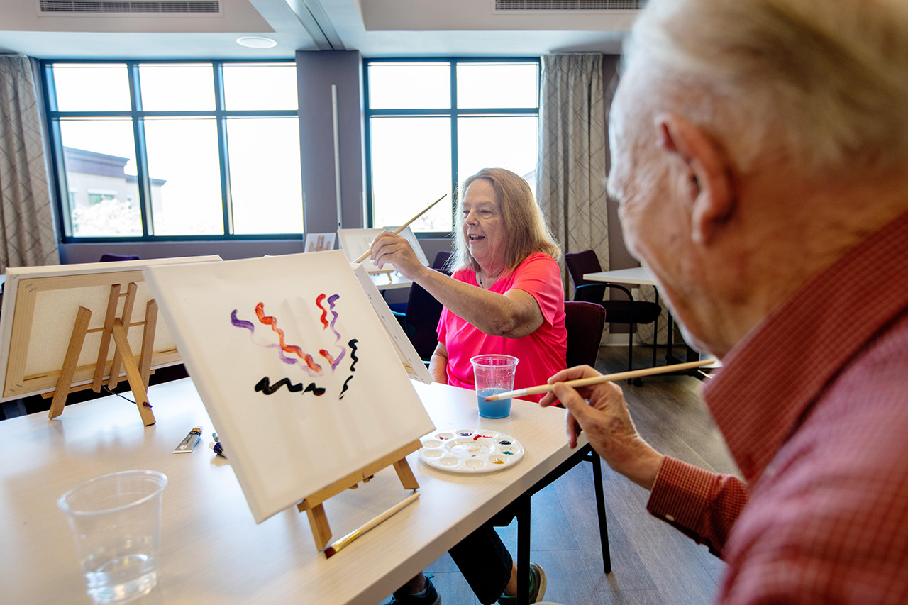 Residents are painting in an art class.