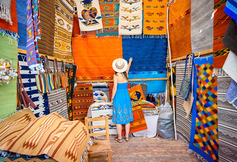 People shopping in a Mexican craft booth.