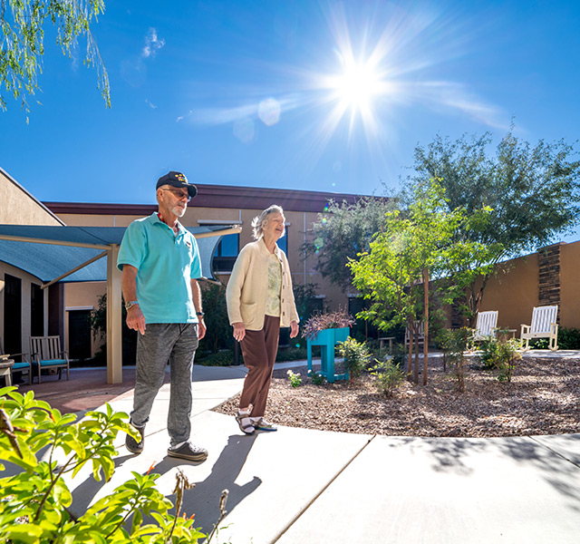 two residents walking outside on sidewalk pathways