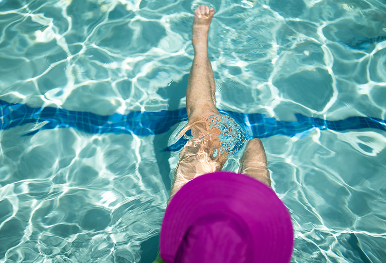A resident in a purple hat in the pool.