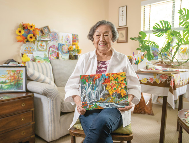 A resident is holding a painting.