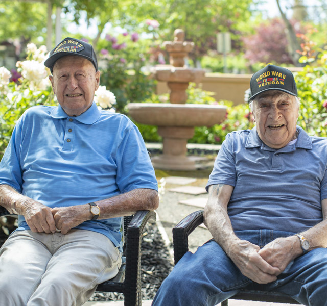 Two residents sitting in the garden at The Watermark at Rosewood Gardens.