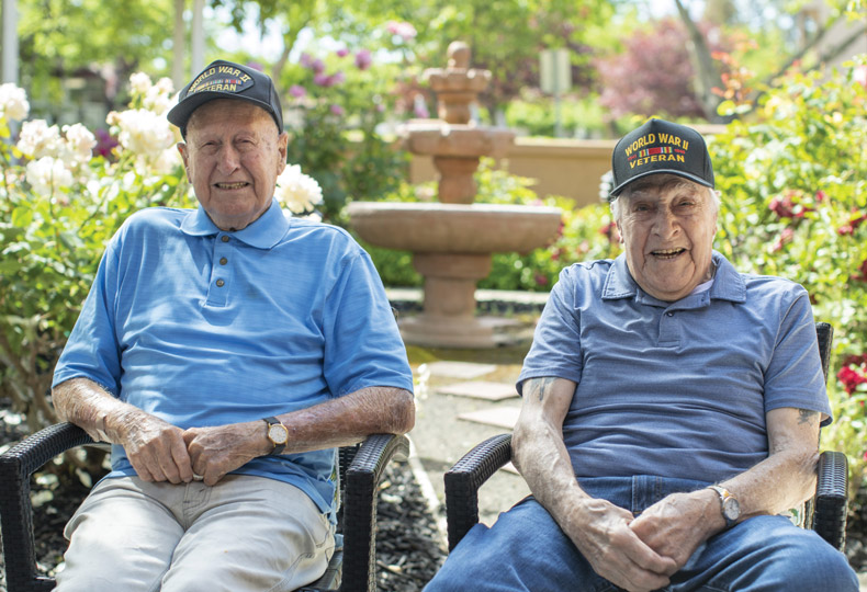 Two residents sitting in the garden at The Watermark at Rosewood Gardens.